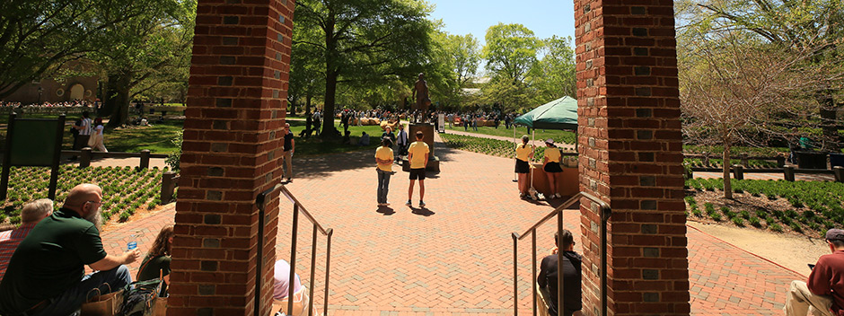 Campus volunteers and visiting students and families resting on the steps of Tucker Hall.